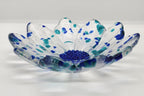 clear glass flower with blue center and blue flecks of glass on  a white background