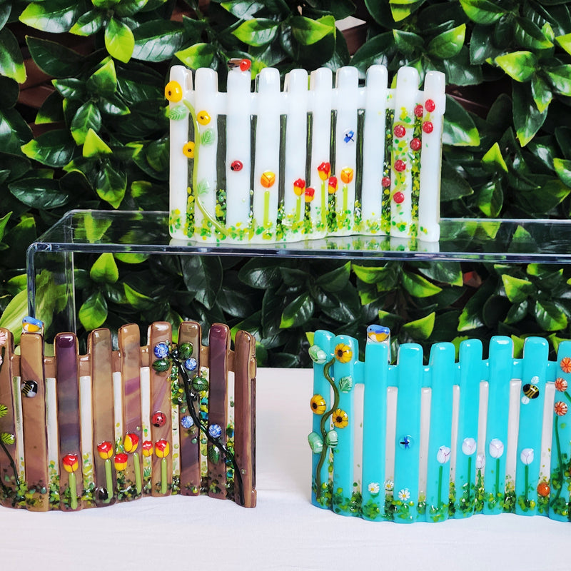 Glass garden fence decorations with bugs and flowers on the fence poles.
