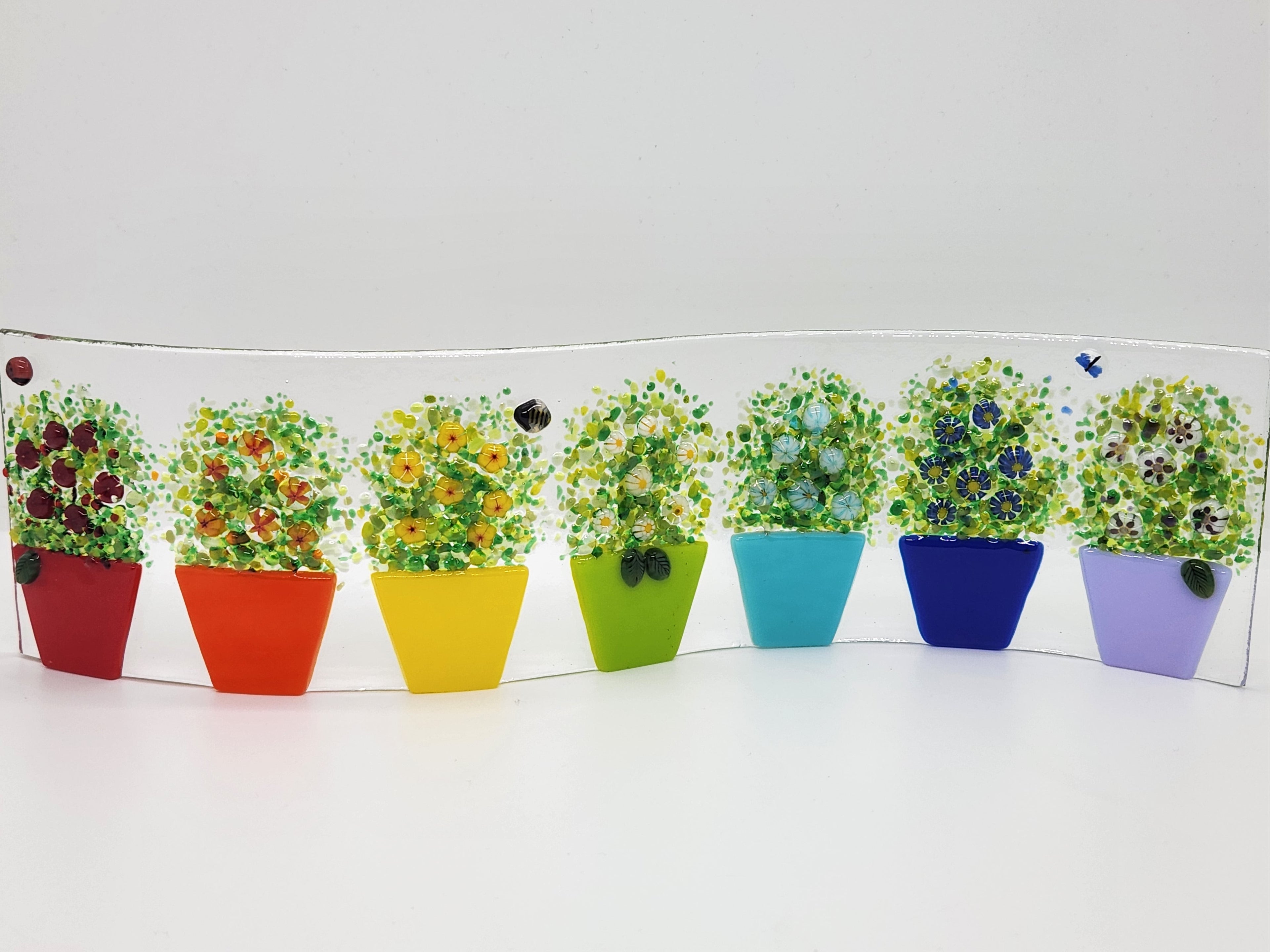 Fused glass Flower Pot Waves featuring rainbow flower pots with blooming greenery on a gently curved glass panel for home decor.