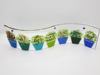 Fused glass Flower Pot Waves featuring blue and green flower pots with blooming greenery on a gently curved glass panel for home decor.