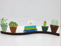 Fused glass Book Shelf Wave featuring colorful books, potted plants, and garden-inspired details on a gently curved glass panel for home decor.