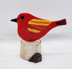 Red songbird on birch wood stand