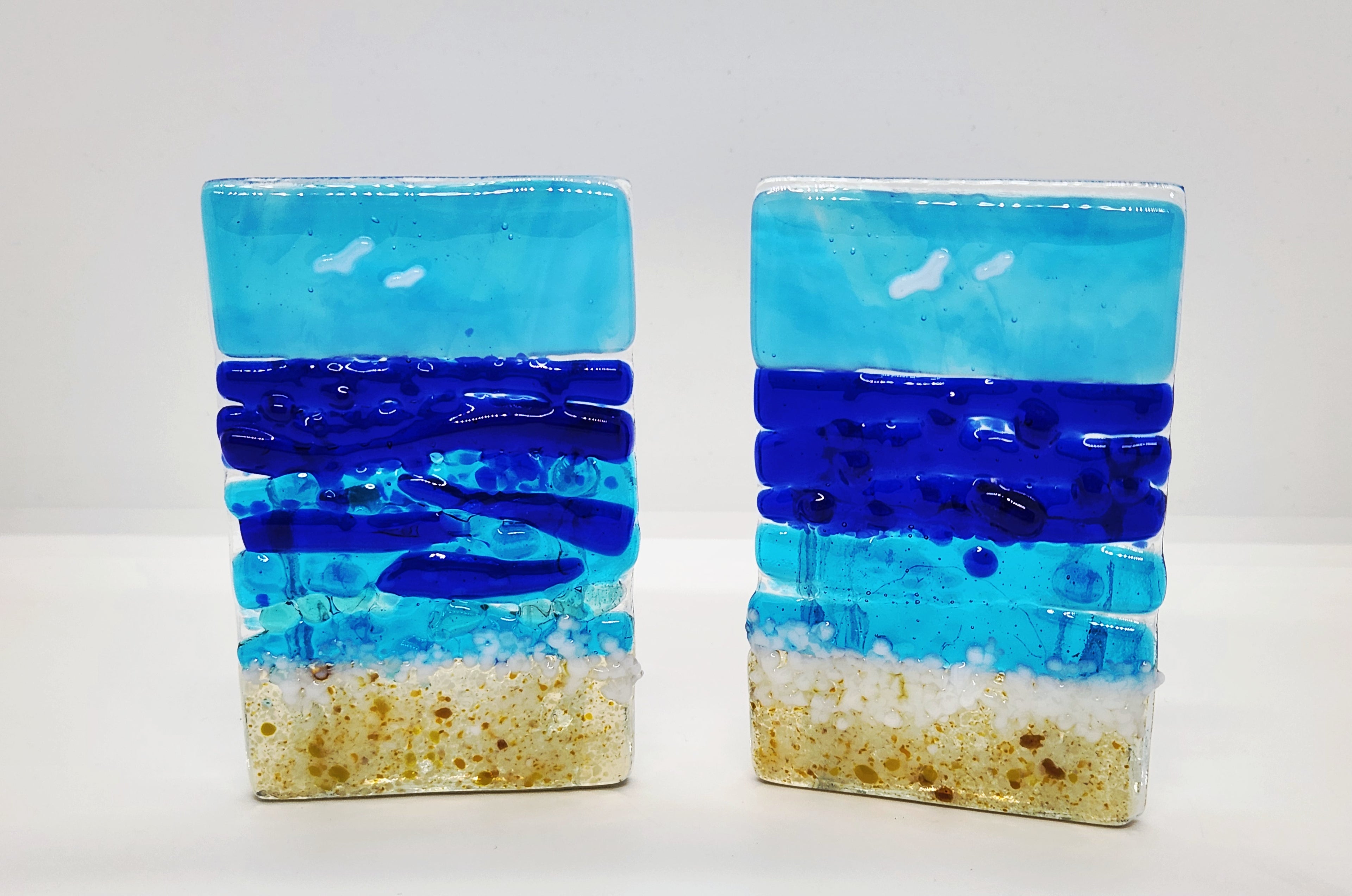 Fused glass Ocean Aqua candle holder with layered aqua, deep blue, and sandy glass, inspired by the colors of the shoreline and designed for home decor.