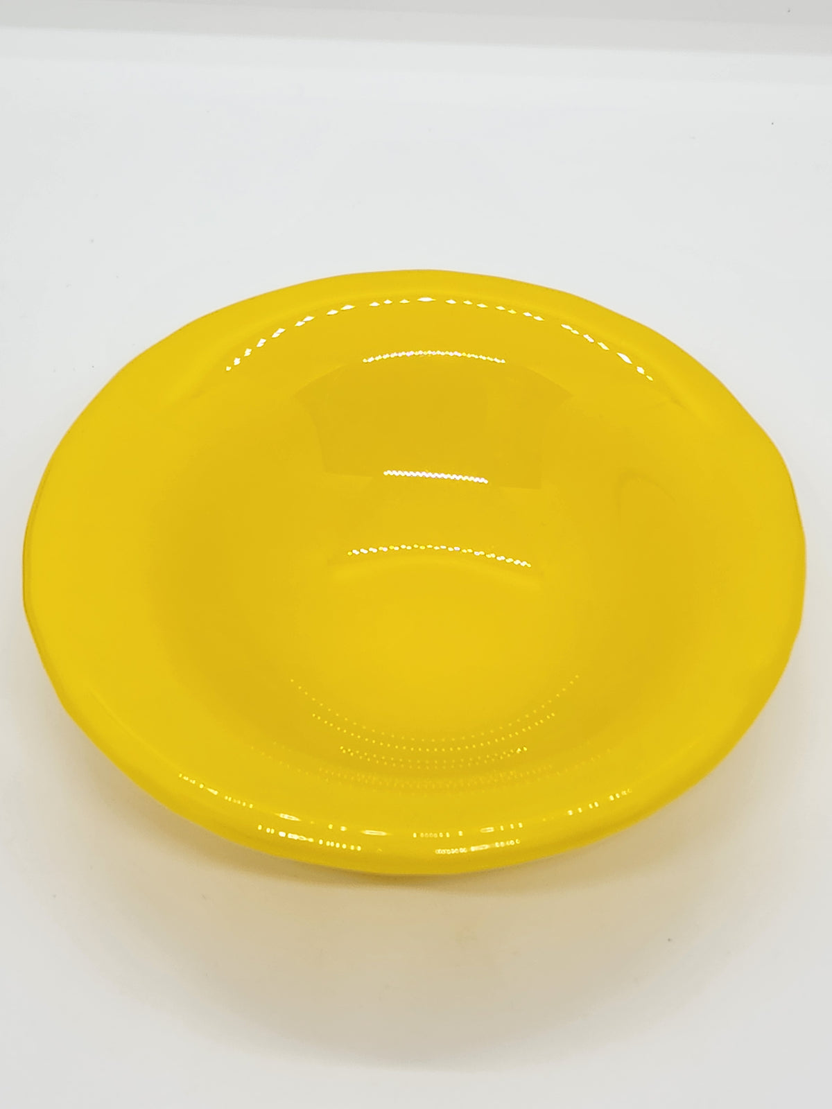 A bright yellow trinket dish with a glossy finish.