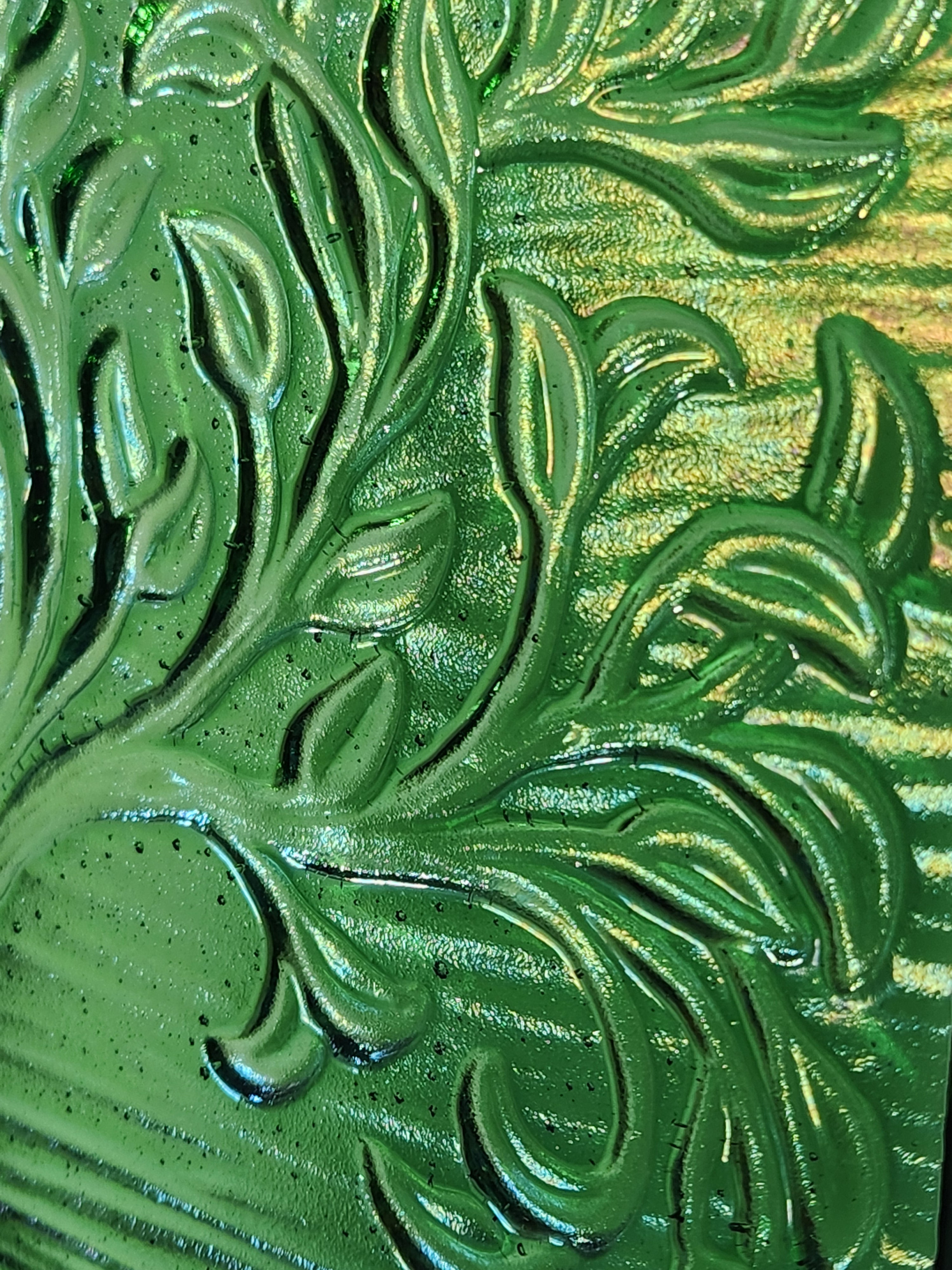 A close up of a square glass art panel featuring the tree of life which has green hues.