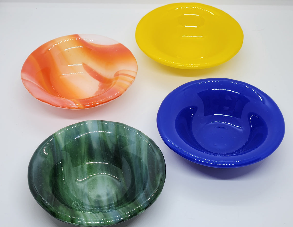 Four trinket dishes in the colors: green, blue, yellow, and orange.