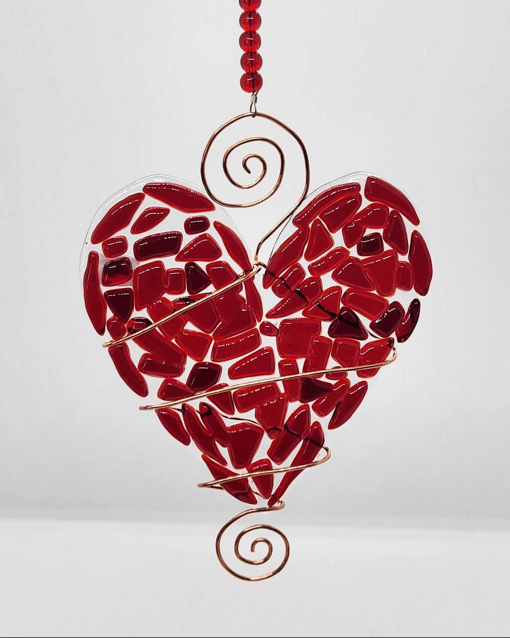 Red heart suncatcher wrapped in copper wire with bead handle.
