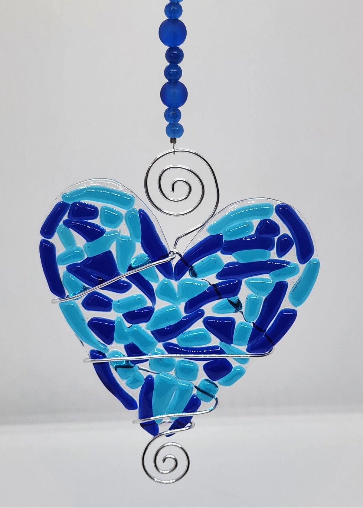 Blue heart suncatcher wrapped in copper wire with bead handle.