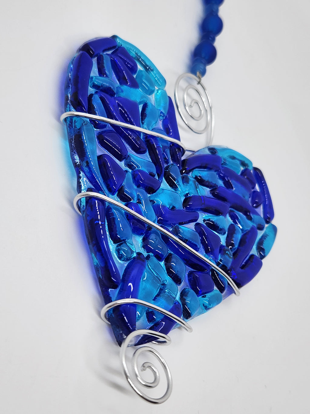 Blue heart suncatcher wrapped in copper wire with bead handle.