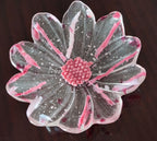 a flower shaped glass bowl on a dark brown surface.