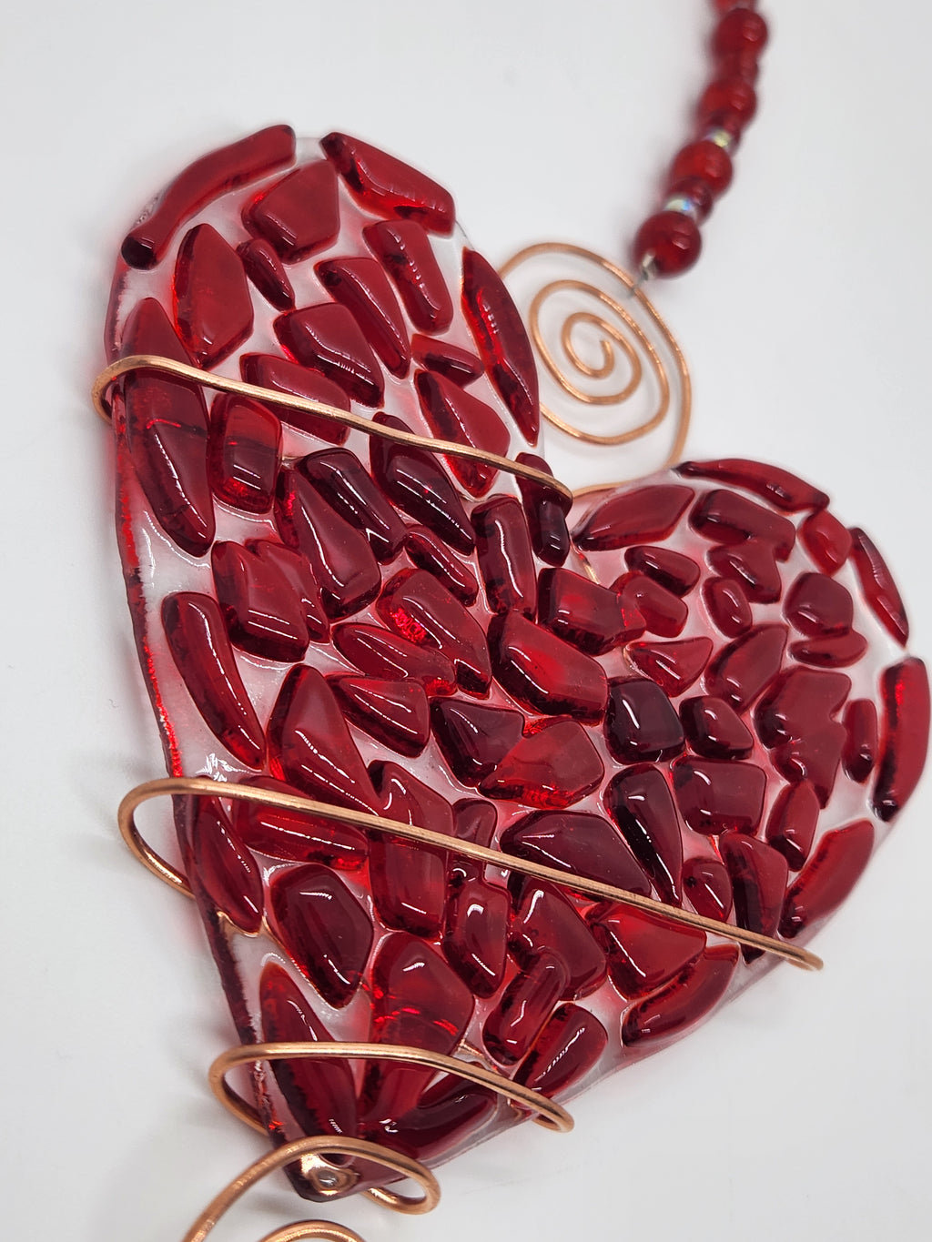Red heart suncatcher wrapped in copper wire with bead handle.