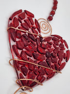 Red heart suncatcher wrapped in copper wire with bead handle.