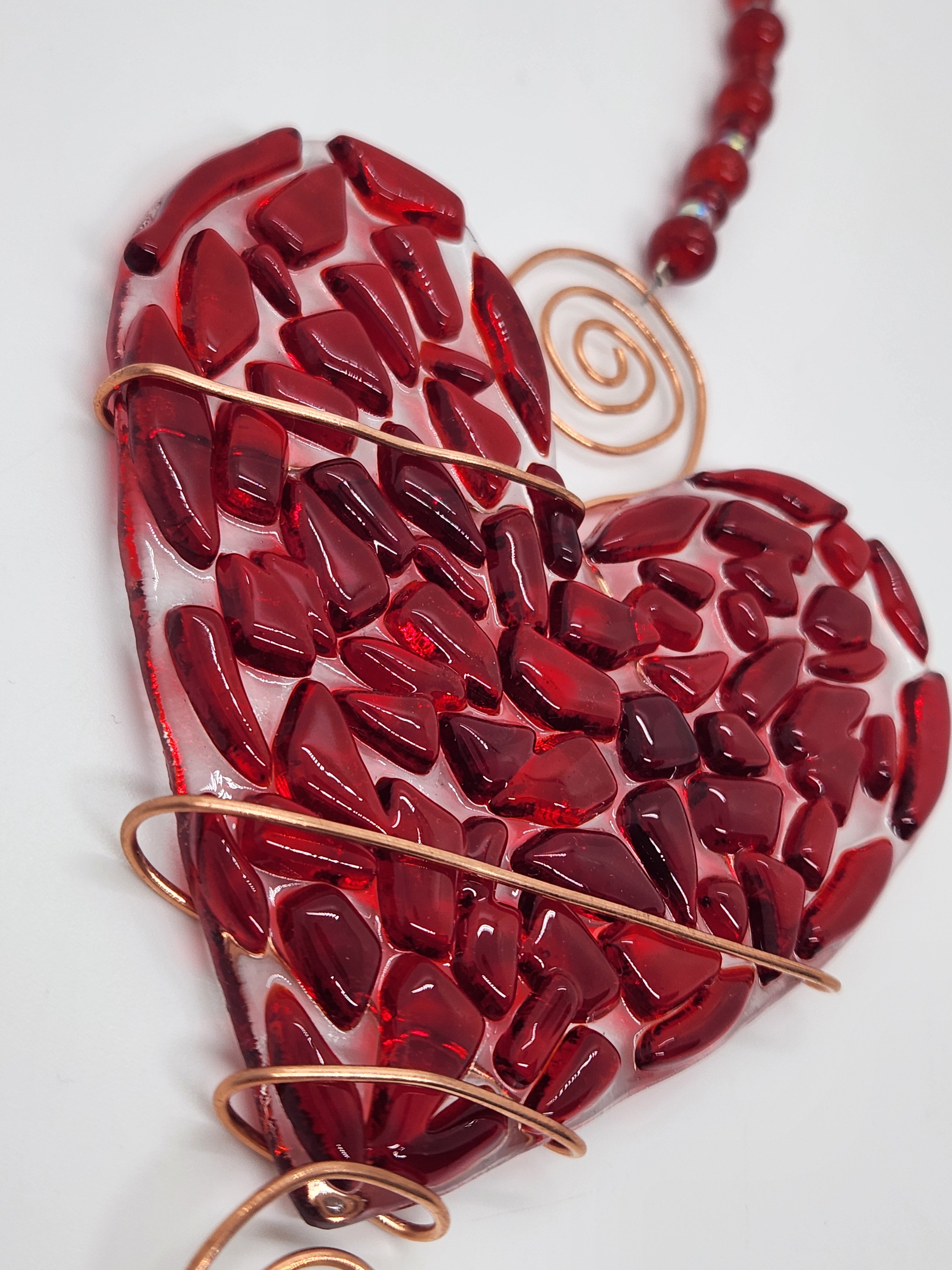 Red heart suncatcher wrapped in copper wire with bead handle.