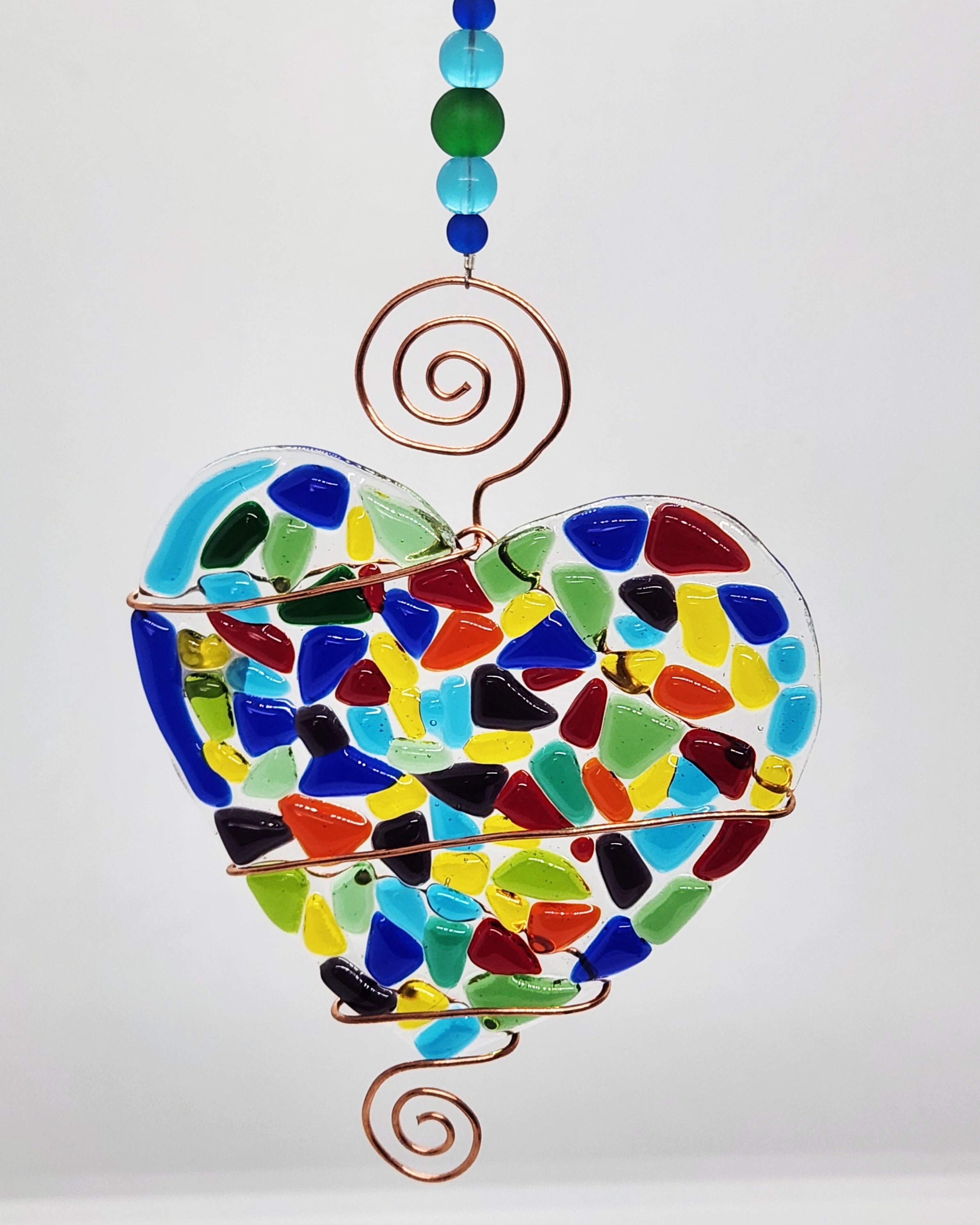 Rainbow heart suncatcher wrapped in copper wire with bead handle.